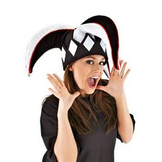 a woman wearing a black and white hat making a silly face with her hands in the air