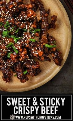 sweet and sticky crispy beef on a wooden plate with chopsticks next to it