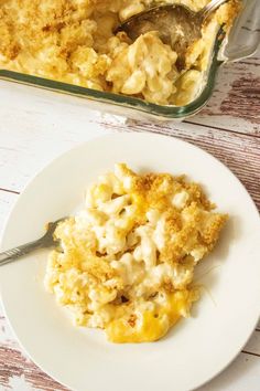 a white plate topped with macaroni and cheese next to a casserole dish