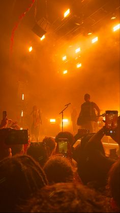 a group of people that are standing in front of some microphones on stage at a concert