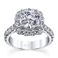 a white gold engagement ring with an oval center surrounded by round diamonds