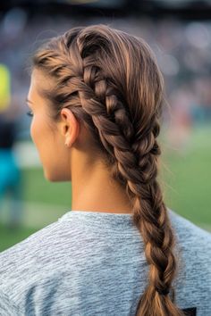 Woman with French braid standing outside in casual attire.