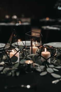 candles are lit on top of a black table cloth