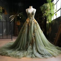 a dress on display in front of a window with green and yellow flowers hanging from it