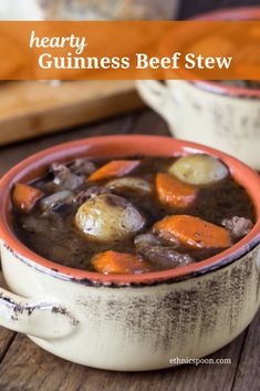 hearty guinness beef stew with carrots and potatoes in a white bowl on a wooden table