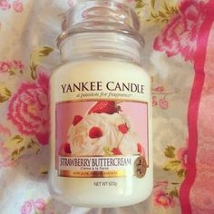 yankee candle strawberry buttercream jar with lid on pink floraled tablecloth background