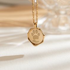 a gold necklace with a dog's paw on it