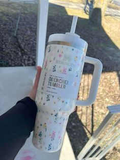 someone is holding up a cup with a straw in it that says, quencher tumbler