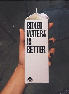 a person holding a carton of boxed water in their hand with the words boxed water is better written on it