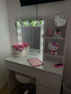 a hello kitty themed desk with flowers and a mirror on the top shelf above it