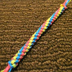 a close up of a multicolored toothbrush on a brown carpet