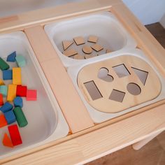 two trays filled with wooden shapes and blocks