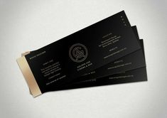 three black and gold business cards on top of each other