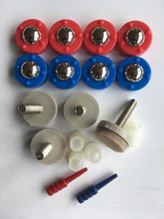 an assortment of buttons and screws on a white surface