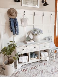 a white bench sitting next to a potted plant on top of a wooden table