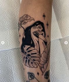 a black and white tattoo on the leg of a woman with a bird in her hand