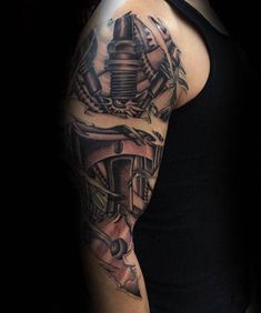 a man's arm with a tattoo on it and an engine in the background