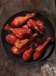 some chicken wings on a black plate