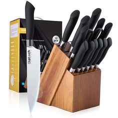 an assortment of kitchen knives in a wooden block with box on the side and packaging behind it