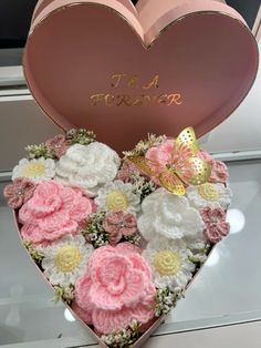 a heart shaped box filled with pink and white flowers