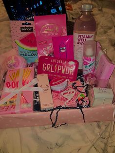 a pink suitcase filled with lots of different types of cosmetics and personal care products on top of a bed