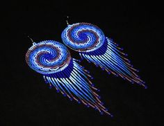 pair of blue and purple beaded earrings with spiral design on black background, closeup