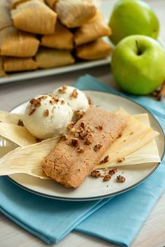 two plates with dessert items on them next to some apples and cinnamon roll sticks in the background