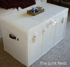 a white trunk sitting on top of a carpeted floor