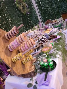 an assortment of donuts and pastries on a wooden platter at a party