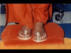 the feet and toes of a person in orange pants with white shoes on top of an orange towel