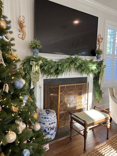 a living room with a christmas tree, fireplace and television on the wall above it