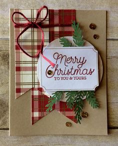 a christmas card made with plaid paper and red ribbon on top of a wooden table