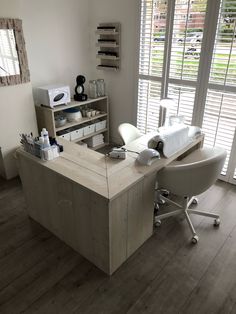 a room with a desk, chair and window in the corner that has shutters on both sides