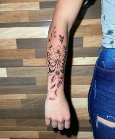 a woman's arm with a flower tattoo on it