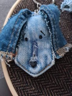 a denim dog keychain hanging from a metal ring on top of a table