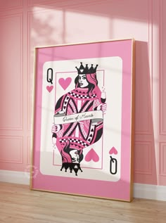 a pink and white playing card in front of a pink wall with hearts on it