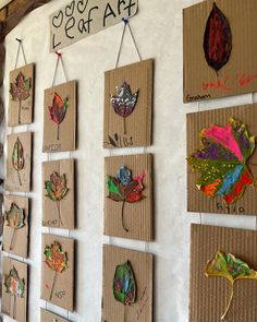 the wall is covered in many different colored leaf shapes and words on cardboard boards with magnets attached to them