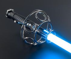 a blue light saber is attached to a metal object on a black surface with a white cord