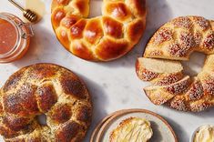 several different types of breads on plates with dipping sauces and honey in the background