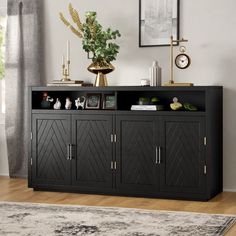 a black entertainment center with gold accents in a living room or dining room, next to a window