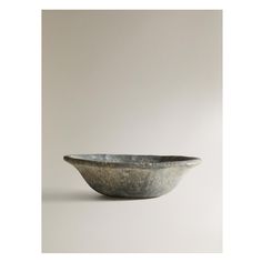 a large bowl sitting on top of a white table next to a gray wall and floor