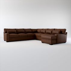 a brown leather sectional sofa sitting on top of a white floor