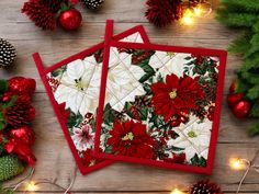 three coasters decorated with poinsettias and pine cones on a wooden table