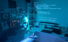 a desk with a computer monitor, keyboard and mouse on it in front of a blue wall