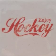 a close up of a white plate with red writing on it and the words enjoy hockey