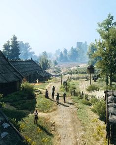 a group of people walking down a dirt road next to grass covered houses and trees