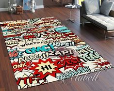 an area rug with comic themed words on it in a room next to a couch