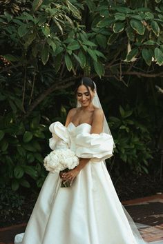 a woman in a wedding dress holding a bouquet