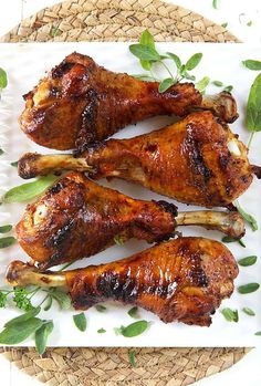 three pieces of chicken sitting on top of a white plate next to some green leaves