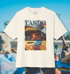 White Racing Style T-shirt With Graphic Print, Racing Style Graphic T-shirt For Sports Events, Racing Style Graphic Print T-shirt For Sports Events, Racing Style Fan Merchandise T-shirt With Logo Print, Racing Style Graphic Print T-shirt For Fans, White Racing Style T-shirt For Sports Events, Auto Racing Events, Formula 1 Racing, Lando Norris